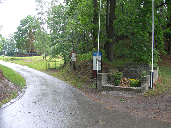 Former access area with memorial stone and information board